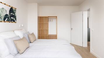 Un dormitorio con una cama grande, un armario de madera y un espejo fijado a la pared.