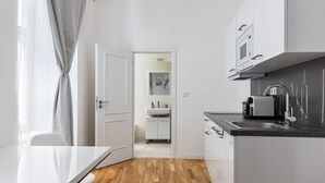 Een moderne keuken met witte kasten, een zwart aanrechtblad en een ingebouwde magnetron.