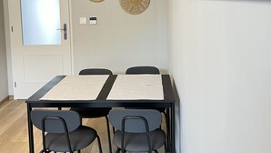 Ein Essbereich mit Tisch, Stühlen und einem Wandbild.