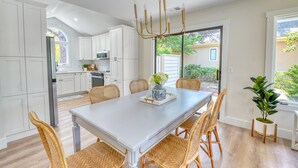 A modern kitchen with white cabinets, a dining table with wicker chairs, and a chandelier. - Fire-Pit & Private Pool. On golf course. Palmetto Dunes, HHI.  (Hilton Head Island)