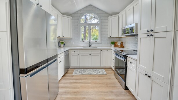 A modern kitchen with white cabinetry, stainless steel appliances, and a large window. - Fire-Pit & Private Pool. On golf course. Palmetto Dunes, HHI.  (Hilton Head Island)