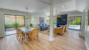 A spacious living area with a dining table and chairs, a sofa, and a view of a swimming pool. - Fire-Pit & Private Pool. On golf course. Palmetto Dunes, HHI.  (Hilton Head Island)