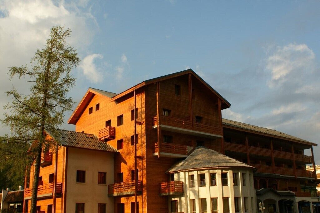 A multi-story building with balconies and a central tower.