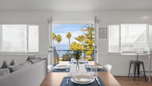 A dining area with a table set for four, overlooking a scenic view of the ocean and palm trees. - Huge Outdoor Space/Steps to Beach & Wedding Bowl (La Jolla)