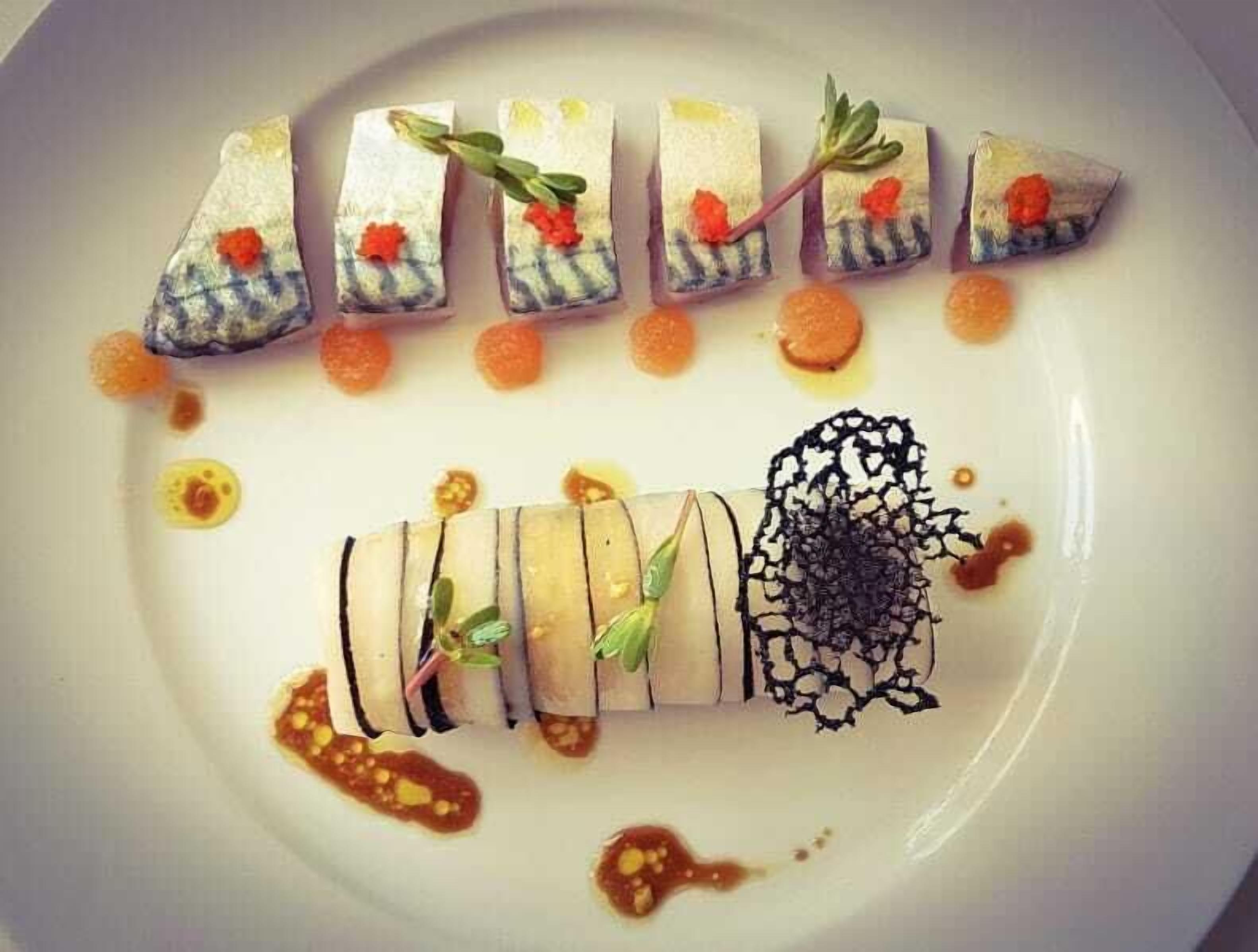 Een bord met diverse soorten eten, waaronder sushi en een decoratieve compositie.