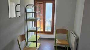 A small, well-lit room with a bunk bed, two chairs, a radiator, and a window with a view. - l'Auberge La Gruppio (Ilonse)