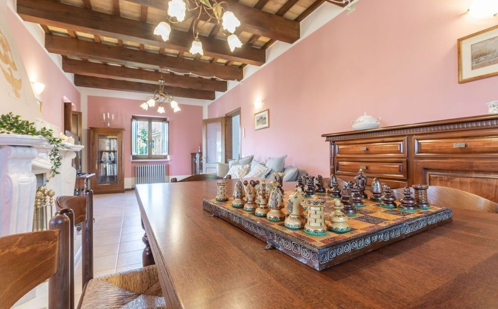 Un comedor con una gran mesa de madera dispuesta para una comida, una chimenea y vistas de la habitación contigua.