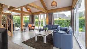 A spacious living area with a large window, a sofa, a coffee table, and a TV.