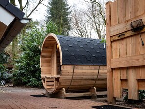 Relax in a secluded sauna or hot tub surrounded by lush greenery and trees.