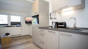 Eine moderne Küche mit Einbauofen, Spüle und Fenster mit Blick ins Freie.