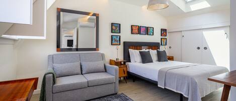 Une chambre moderne avec un canapé, un lit et une fenêtre de toit.