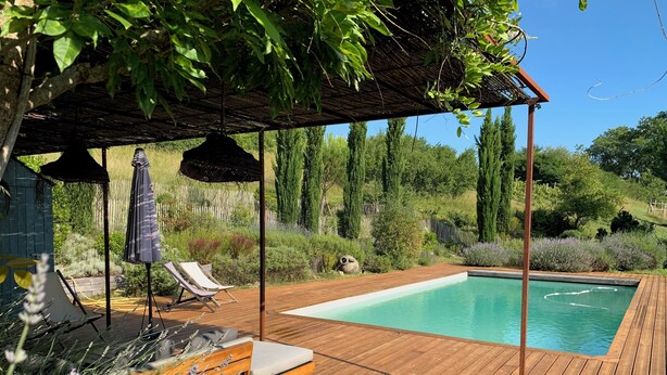 A wooden deck with a pool, lounge chairs, and a pergola with a thatched roof. - Séchoir à Tabac Contemporain (Aillas)