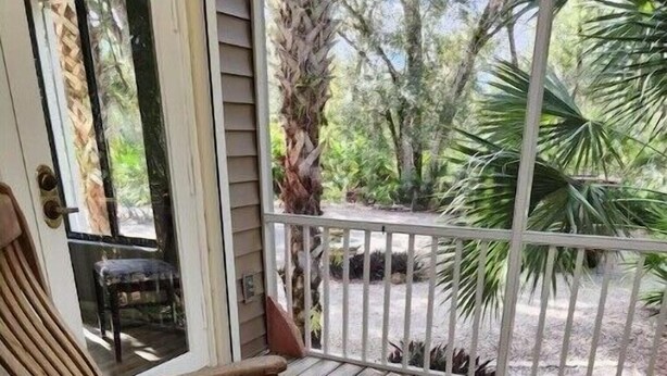 Een houten terras met twee houten stoelen en een kleine tafel.