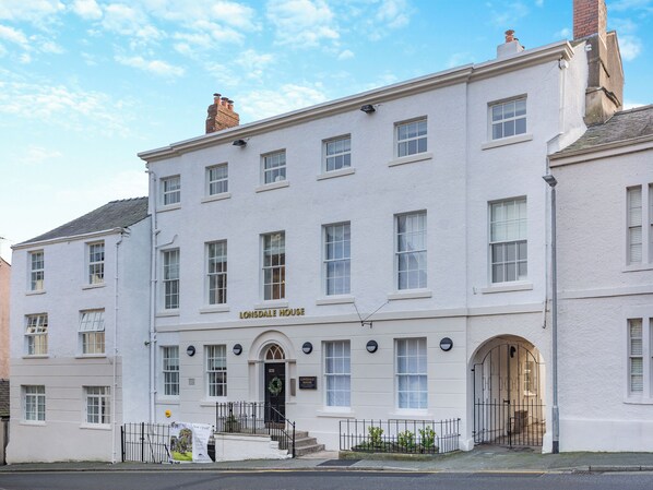 A white building with multiple windows and a sign reading "Lonsdale House".