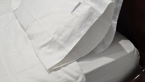 A bed with white bedding and a wooden headboard. - Pakenham Villa (Pakenham)