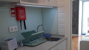 Une cuisine moderne avec des meubles blancs, un four encastré, un grille-pain et un évier.