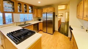 A modern kitchen with wooden cabinets, stainless steel appliances, and a large window. - Fall Color Specials, near Apple Orchards, with Lake & Island Views (Bayfield)