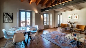 Une pièce spacieuse avec un plafond en bois, une table à manger avec des chaises et une grande fenêtre.