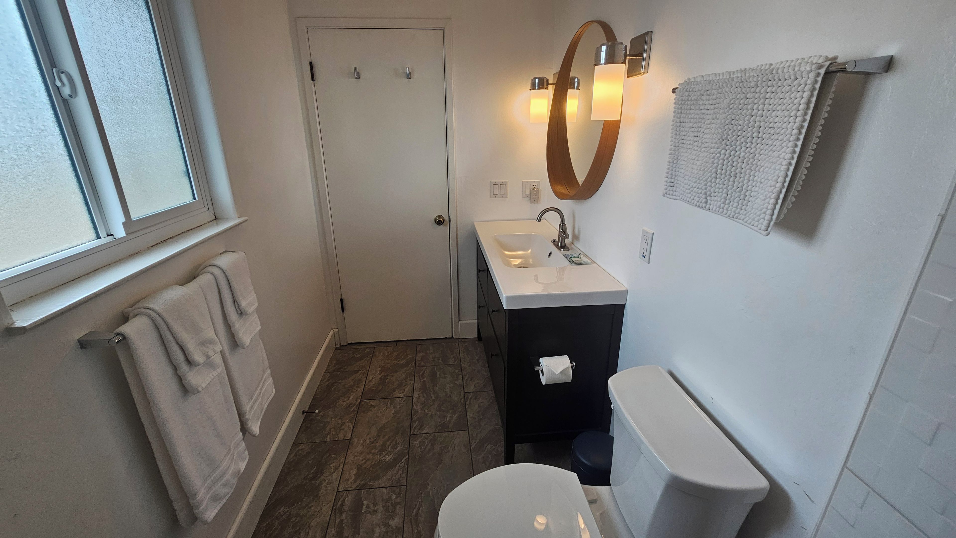 Un baño pequeño con inodoro, lavabo y espejo superior.