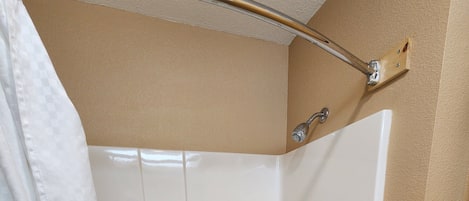 A modern bathroom with a freestanding bathtub, a shower curtain, and a towel rack.