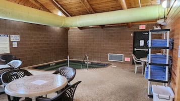 Un spa con piscina, zona de estar y toalleros.