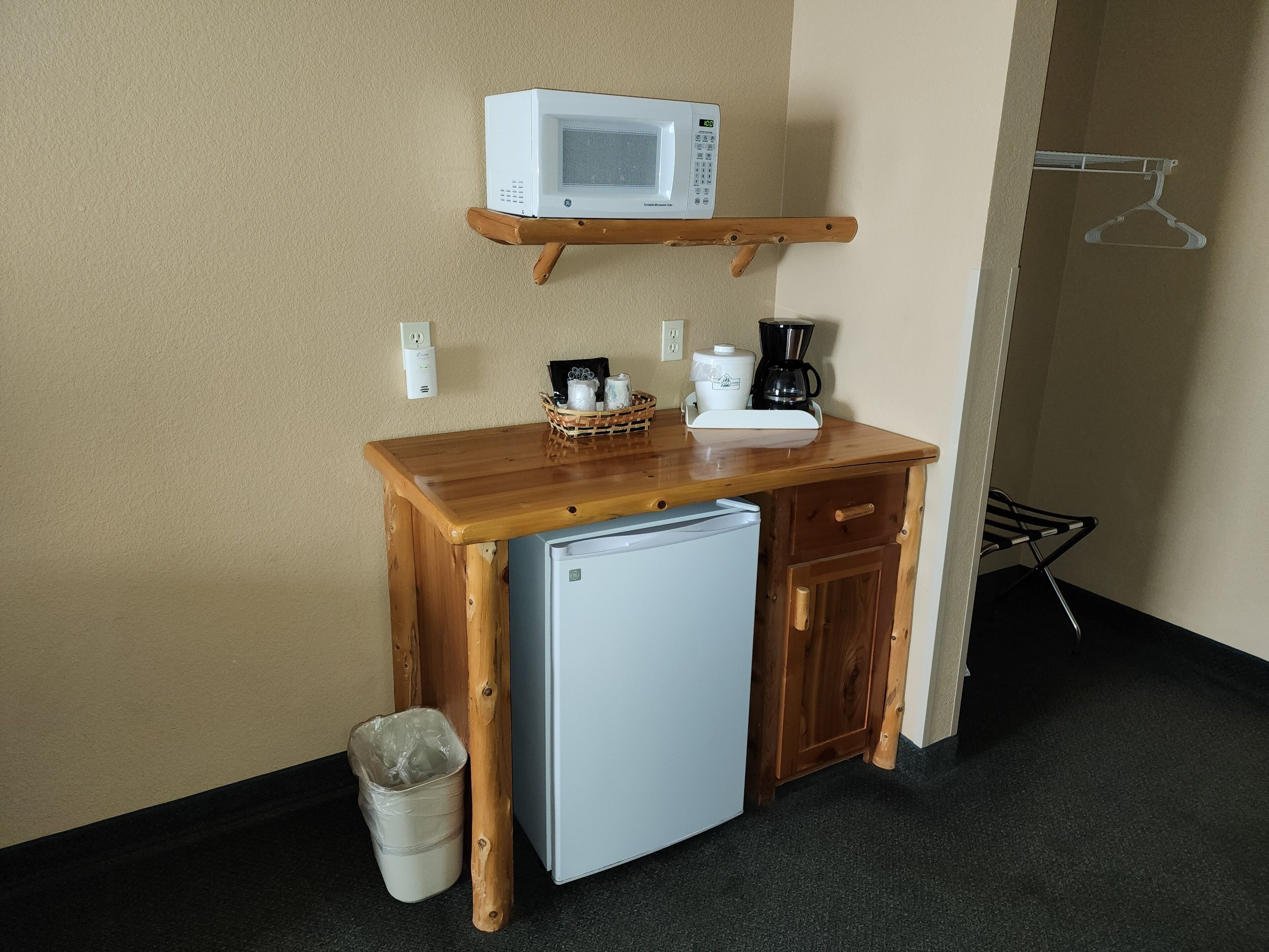 A compact kitchenette with a microwave, coffee maker, and a small refrigerator.