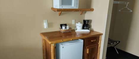 A compact kitchenette with a microwave, coffee maker, and a small refrigerator.