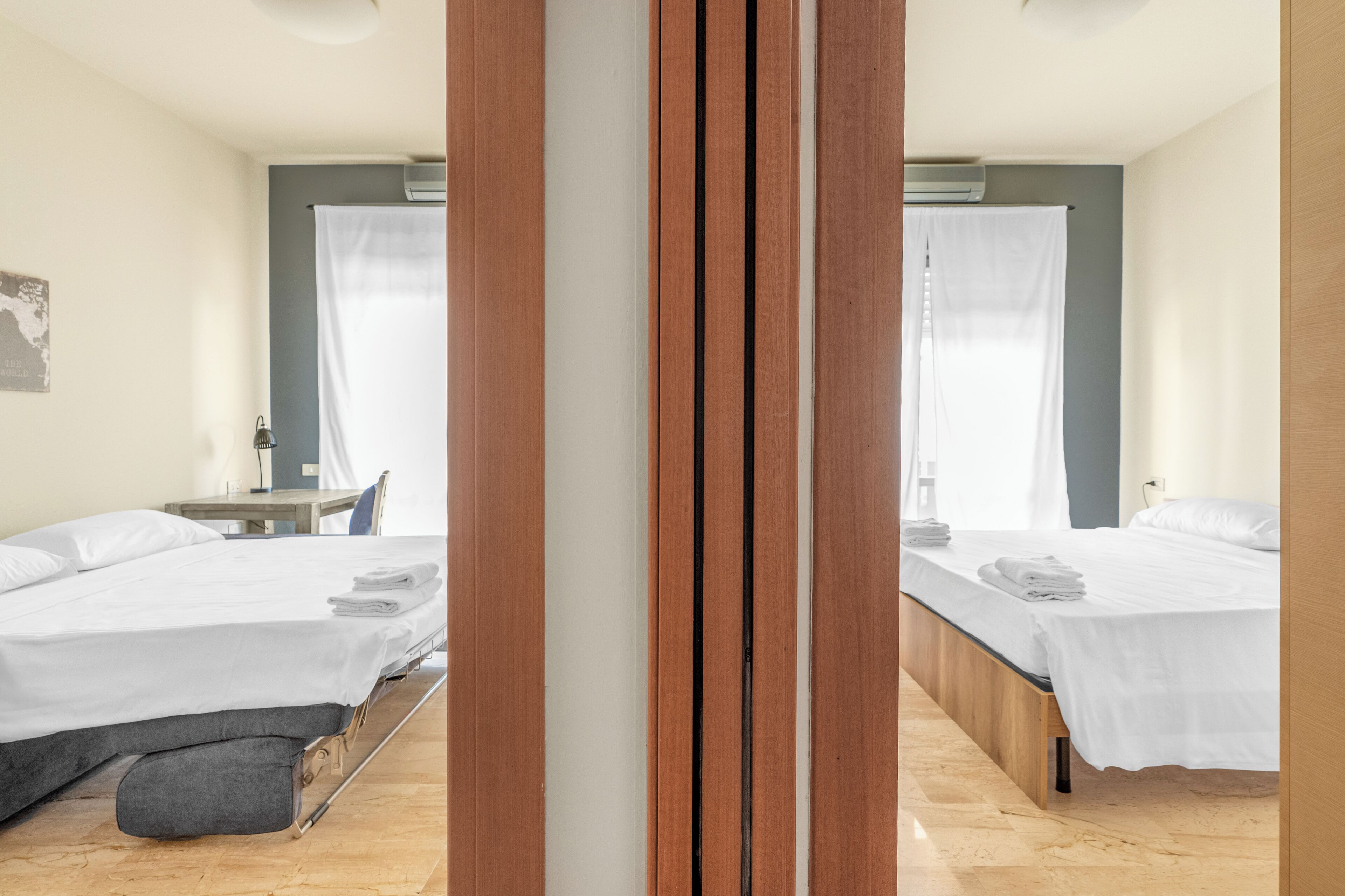 Une chambre d’hôtel avec deux lits, un bureau et une chaise.