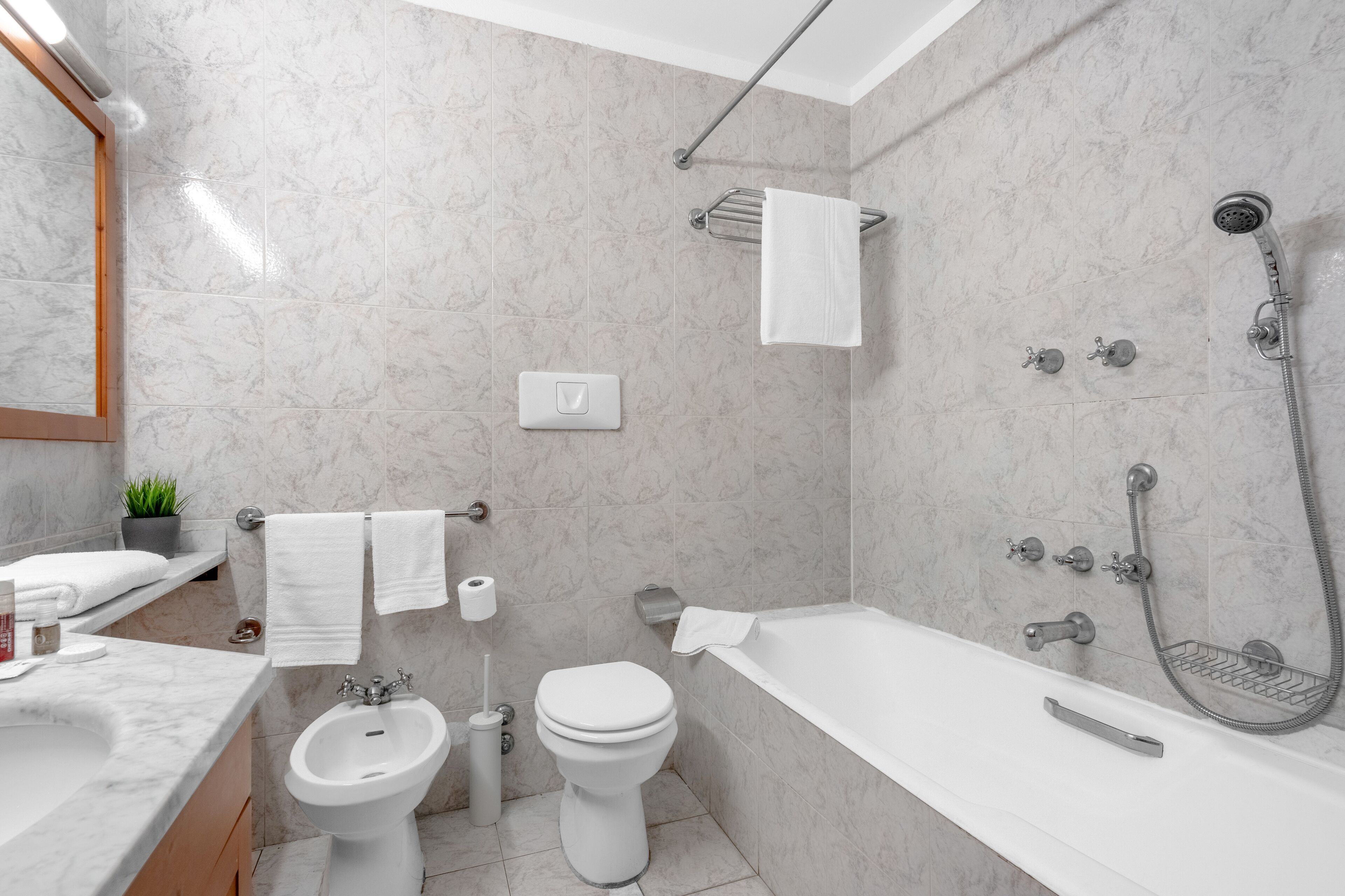 Un baño moderno con bañera, ducha, lavabo e inodoro.