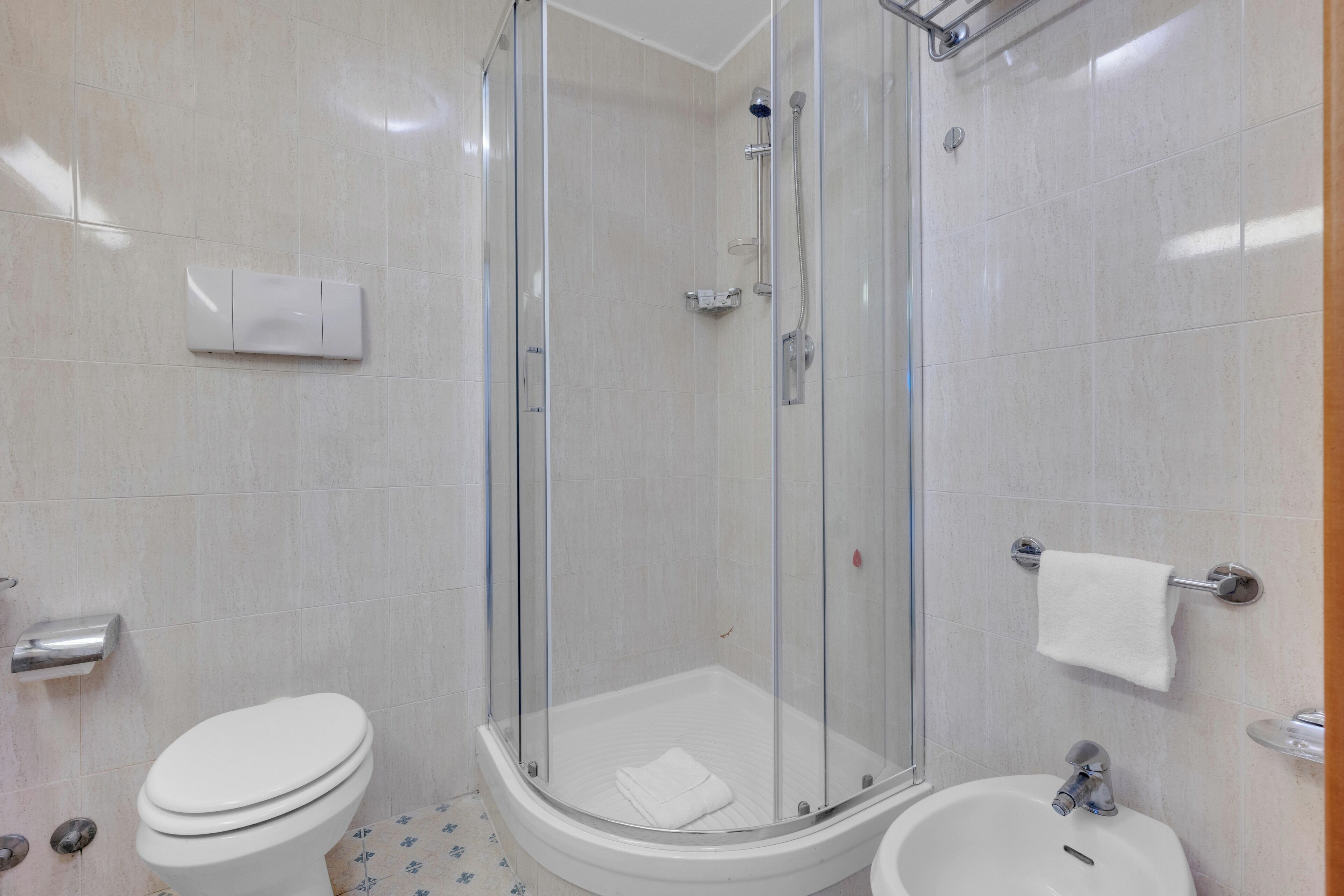 Ein modernes Badezimmer mit einer Duschkabine, einer Toilette und einem Waschbecken.