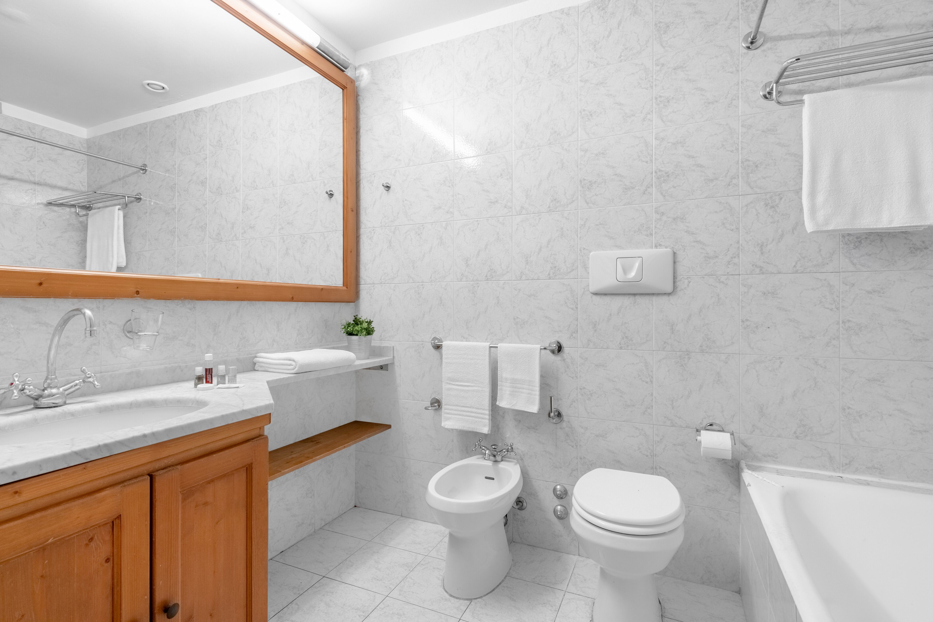 Une salle de bain moderne équipée d’un lavabo, d’un bidet, de toilettes et d’une baignoire.