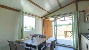 A room with a wooden table and chairs, a window, and a sliding glass door leading to an outdoor area.