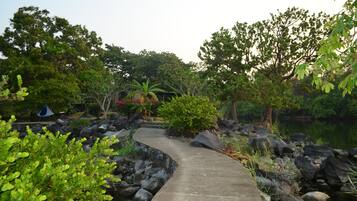 A concrete pathway leading through a natural setting with rocks and greenery.