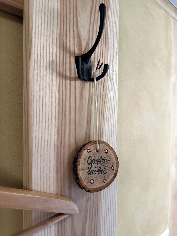 Una puerta de madera con un manillar de metal negro y una placa redonda de madera con texto.