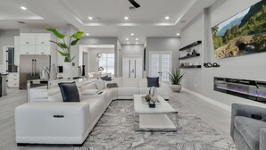 A modern living room with a sectional sofa, a coffee table, and a fireplace. - Amazing Mansion on Toho (Kissimmee)