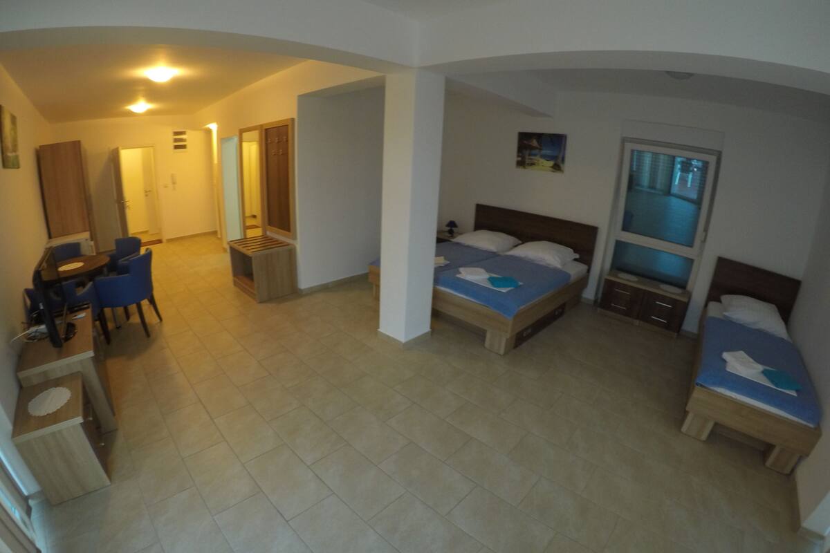A hotel room with a bed, a desk, and a chair.
