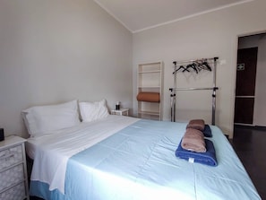 A hotel room with a bed, a nightstand, a wardrobe, and a towel rack. - Bernardo's Place (Ponta Delgada)