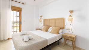 A bedroom with a large bed, two bedside tables, a wooden headboard, and two wall-mounted lamps. - A (VA068) TH Port Saplaya con vistas al Mar. (Alboraya / Alboraia)