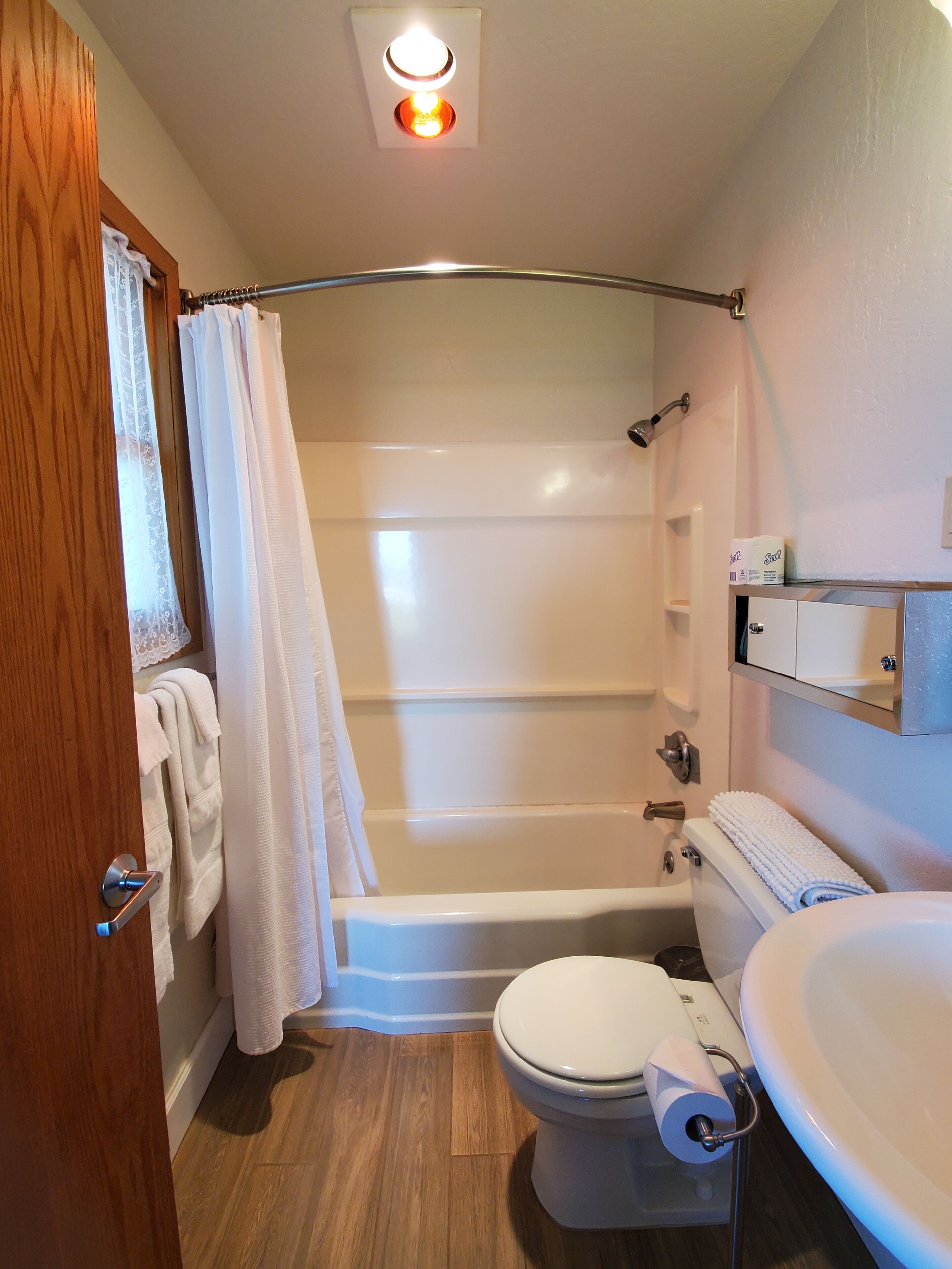 A bathroom with a shower, toilet, and sink.