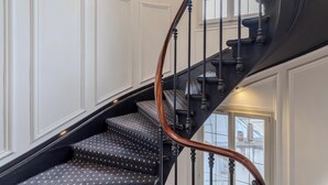 A staircase with a wooden handrail and black steps with white dots. - Hotiday Room Collection - Paris Arc de Triomphe (Paris)