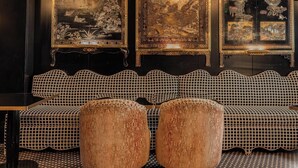 A room with a dark wooden wall, a black sofa with a checkered pattern, and three framed artworks with intricate designs. - Hotiday Room Collection - Paris Arc de Triomphe (Paris)