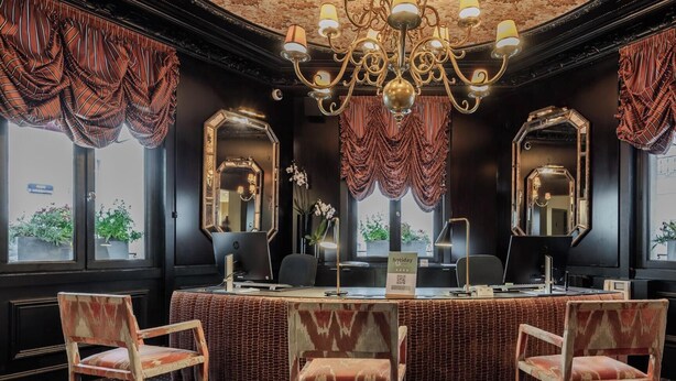 A hotel lobby with a reception desk, two chairs, a chandelier, and large mirrors. - Hotiday Room Collection - Paris Arc de Triomphe (Paris)