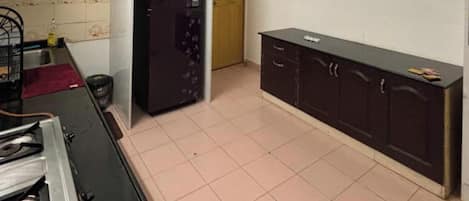 A kitchen with a refrigerator, a stove, a sink, and cabinets.