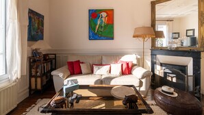 A living room with a sofa, a coffee table, a fireplace, and a large mirror. - Le Refuge de Charentonneau - A 30 min de Paris (Maisons-Alfort)
