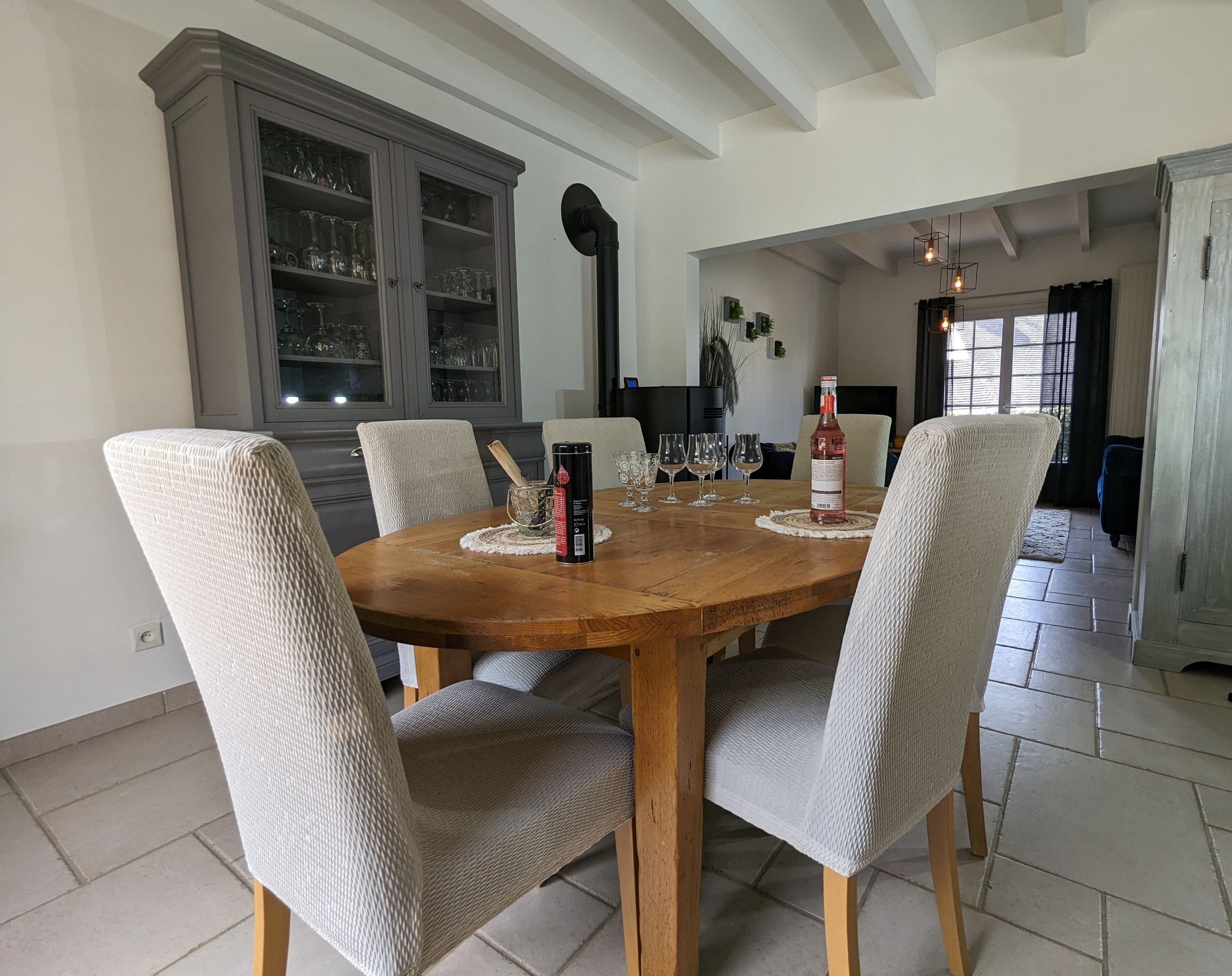 A dining area with a wooden table, six chairs, and a cabinet with glass doors.
