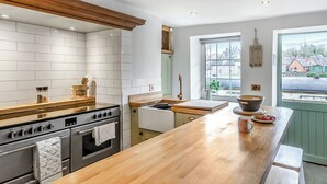 Eine moderne Küche mit weißen Fliesen, Holz Arbeitsplatten und einer großen Kochinsel.