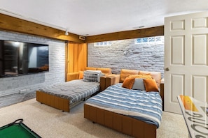 Une chambre à coucher avec un lit, deux canapés, une télévision et une porte.