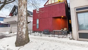 Moderni punainen rakennus, jossa on suuri ikkuna ja parveke.