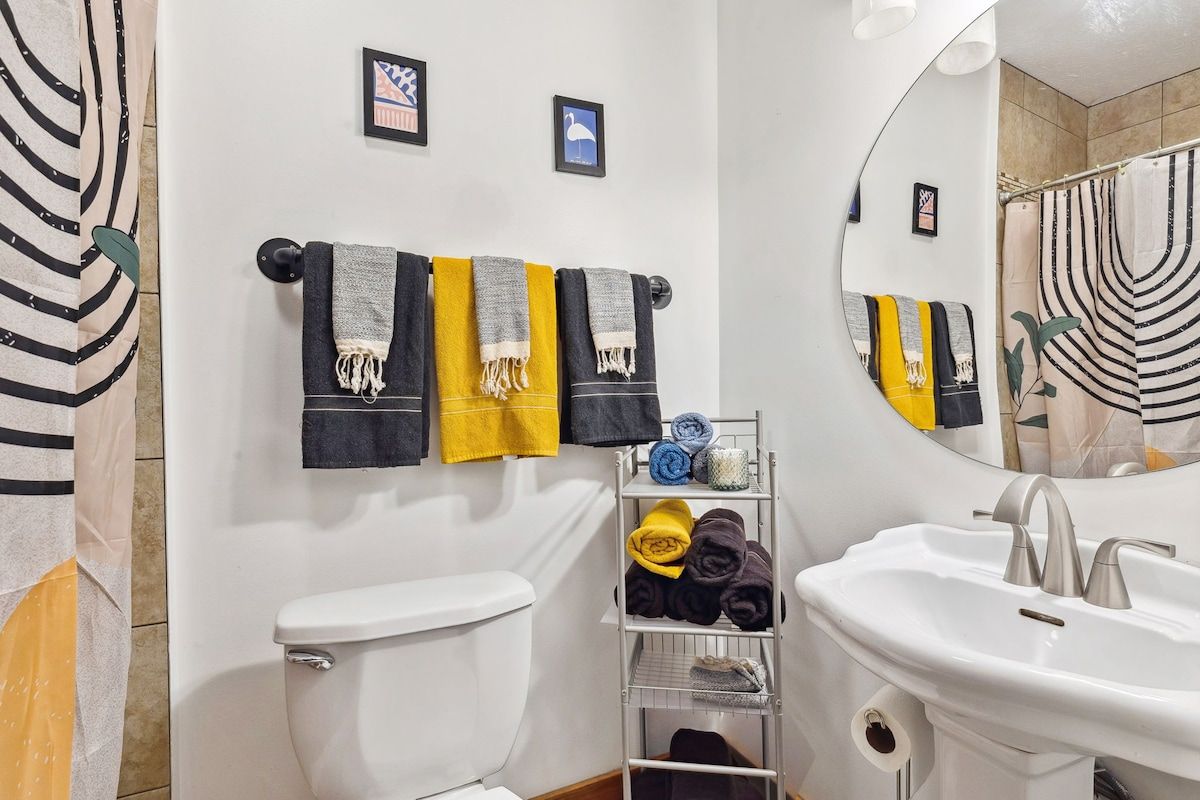 Une salle de bain équipée de toilettes, d’un lavabo, d’un porte-serviettes et d’un miroir.
