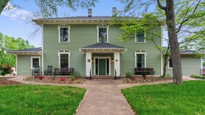 A two-story house with a front porch, a driveway, and a well-maintained lawn.